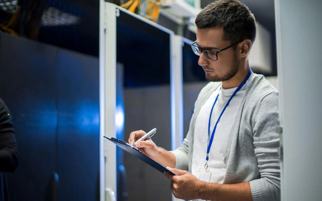An engineer inspecting equipment in a server room